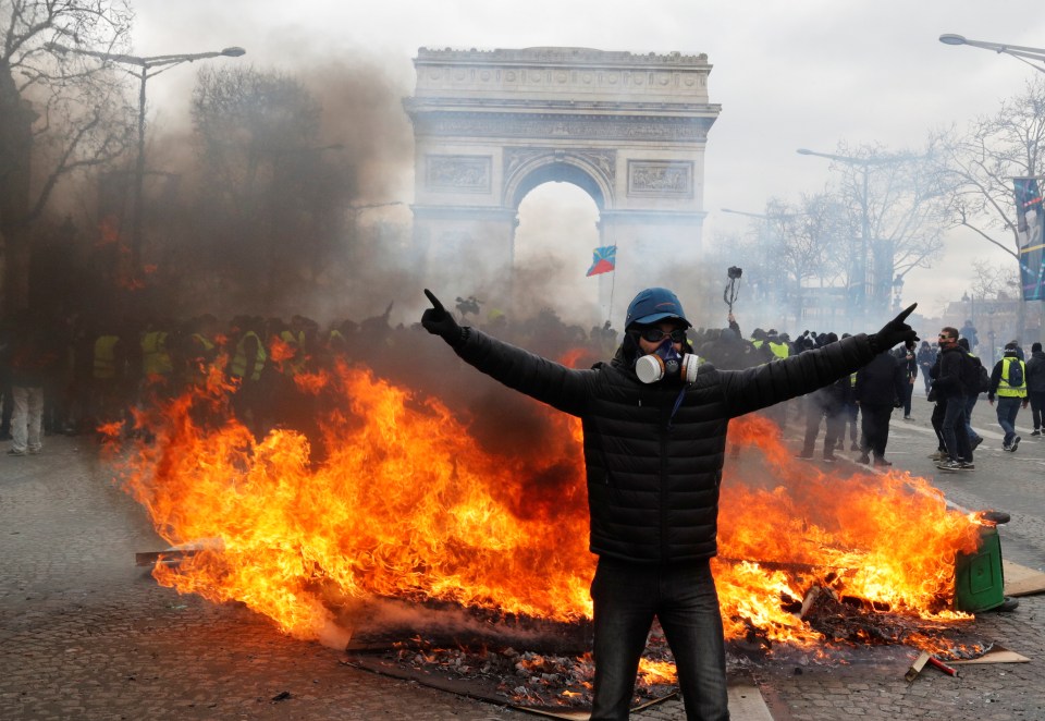  A protester stands in front of burning barricade in the shadow of the Arc de Triomphe during last week's riots in Paris