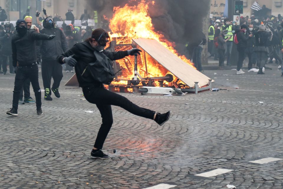  A Yellow Vest protester attempts to throw back a tear gas canister during clashes last week