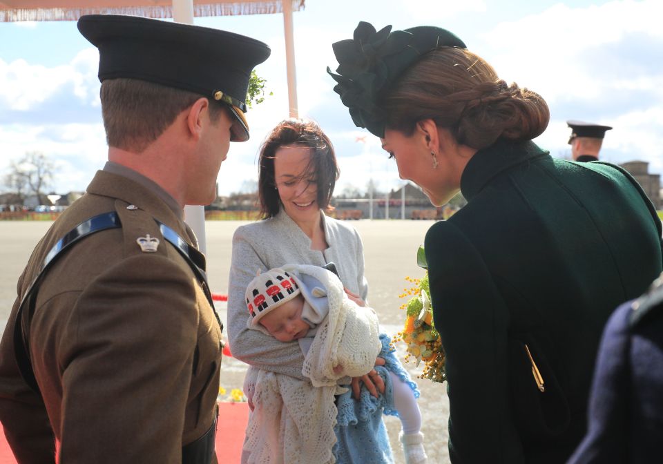  The Duchess smiles as she meets a baby at the ceremony