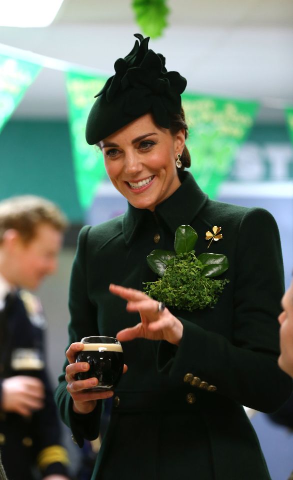  Kate Middleton holds the glass of Guinness as she chats with officers