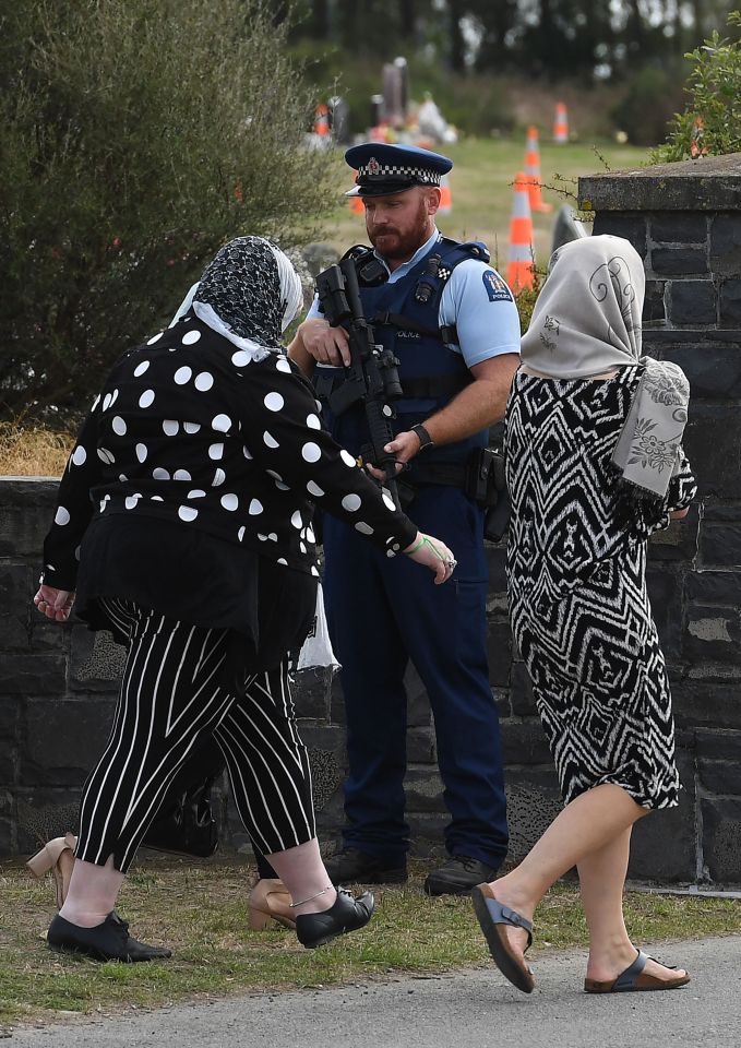  An armed officer watches as mourners enter. The victims had only arrived in New Zealand months ago to escape the violence in Syria