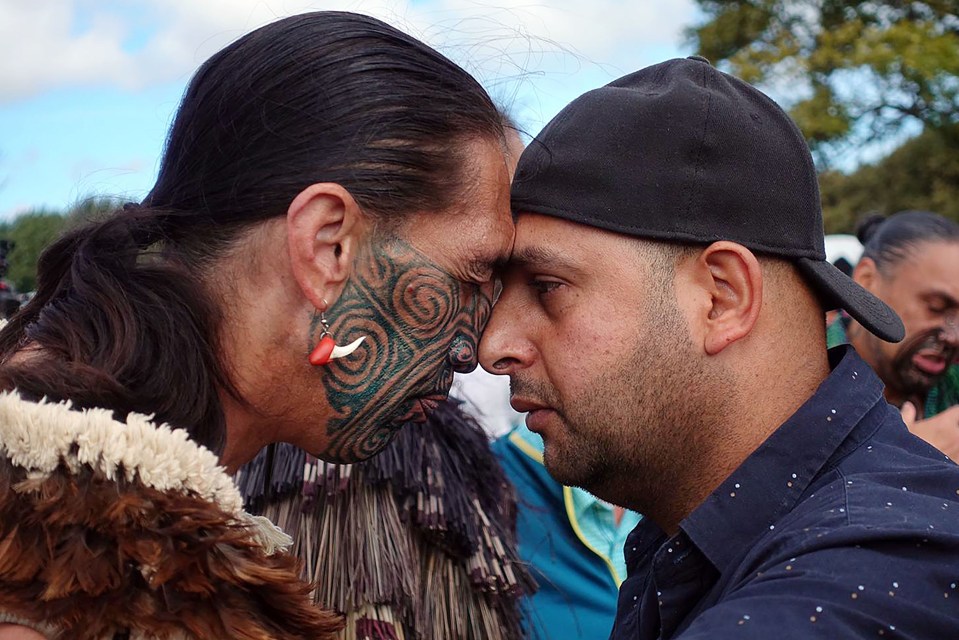 A Muslim man and another local perform a traditional Maori ‘hongi’ greeting during a gathering for congregational Friday prayers