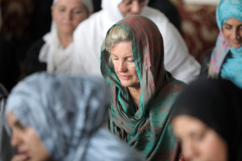 Local residents with head scarfs listen to sermons by the Imam during a call to prayer and moments of silence at Masjid Umar mosque in Auckland