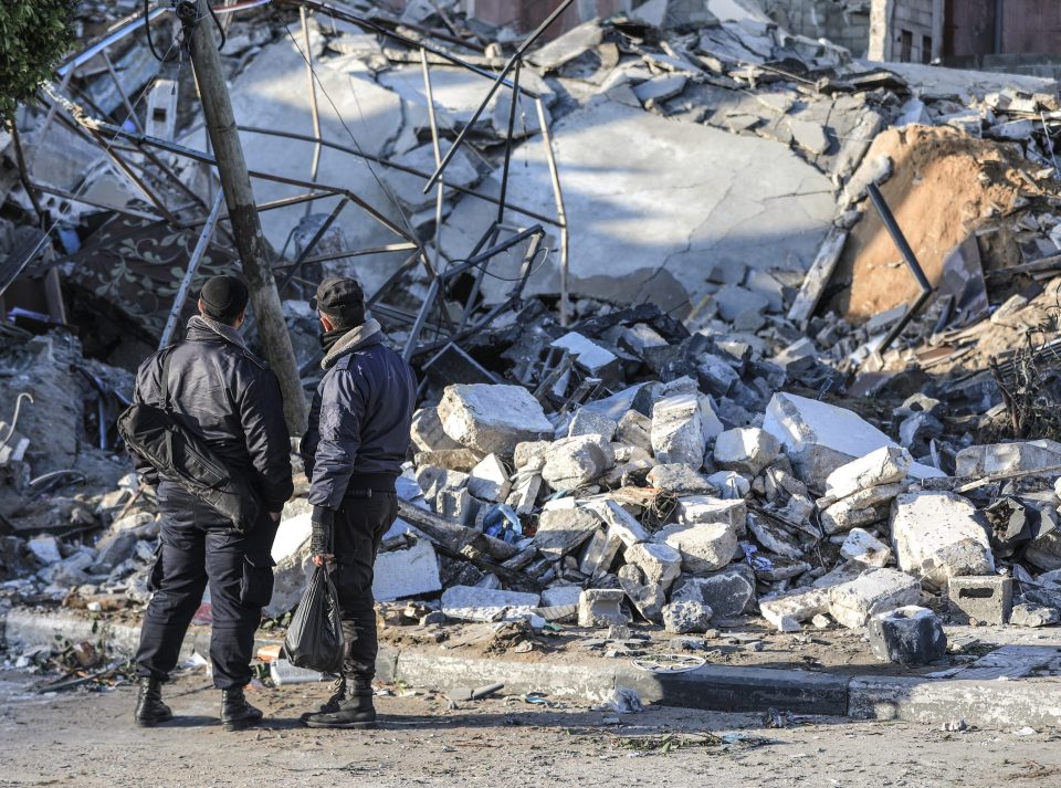  Palestinians inspect a demolished building after Israeli warplanes hit Gaza City