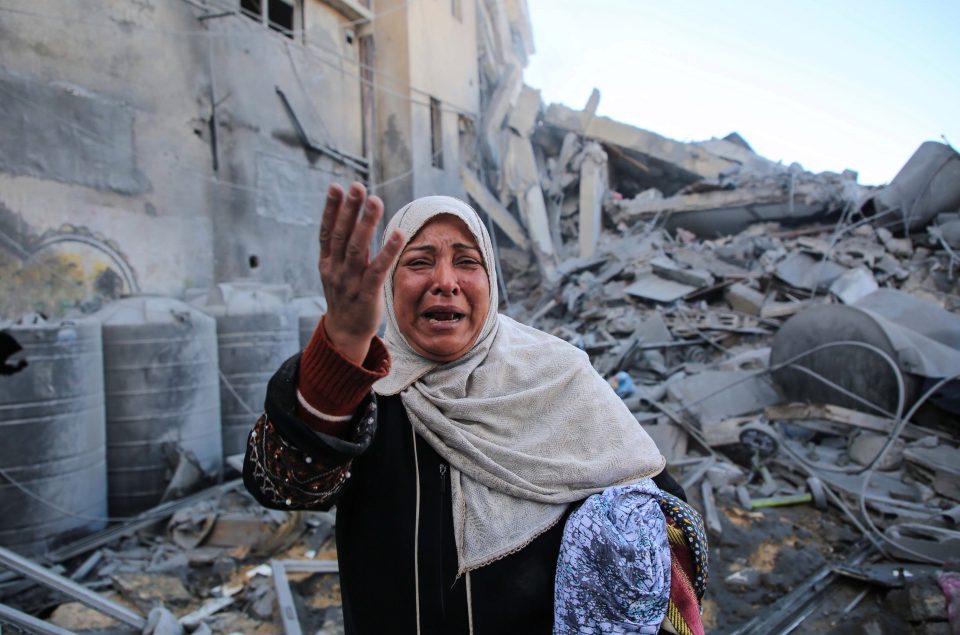  A woman stands in the rubble after Israeli warplanes carried out airstrikes in Gaza City