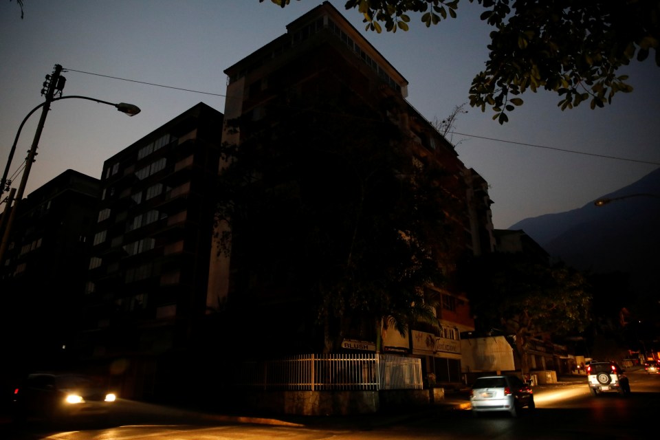  Cars drive past darkened apartment blocks