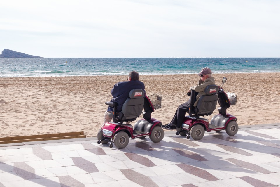  A pair of pensioners relaxing by the sea in Benidorm