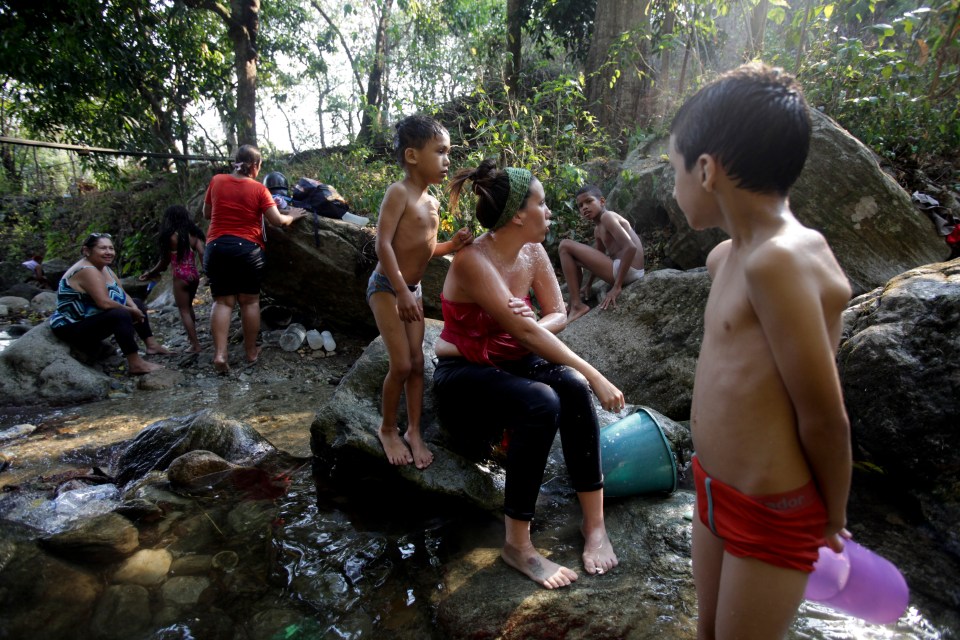  People bath at a brook in Caracas