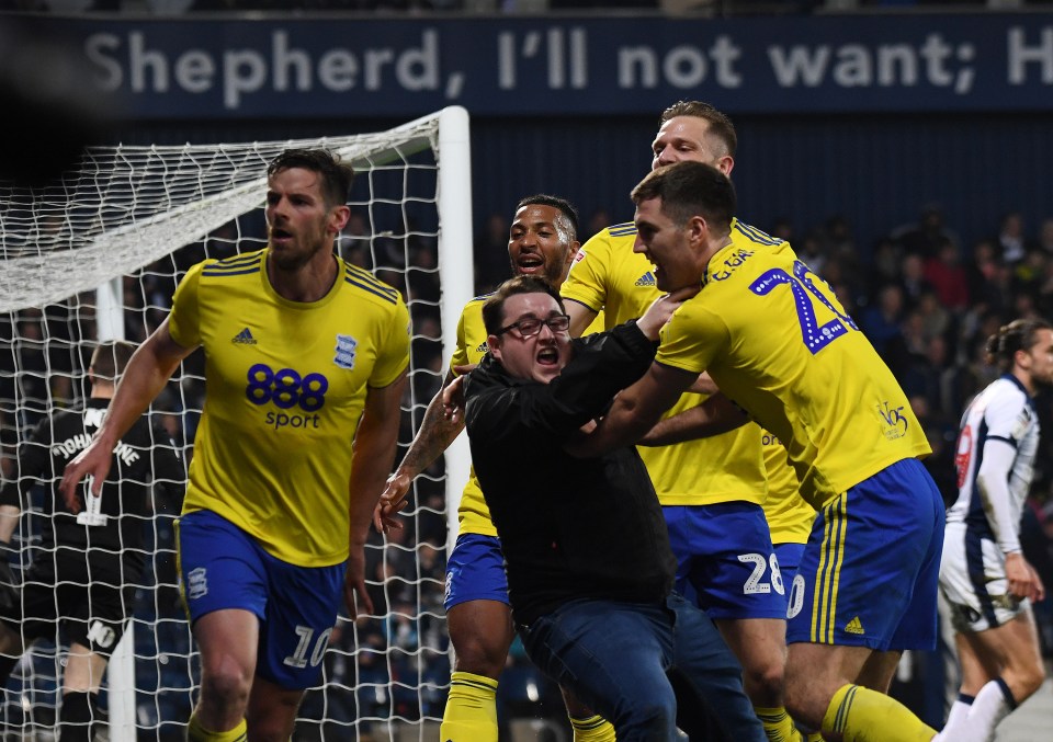  A pitch invader is being restrained by Birmingham players