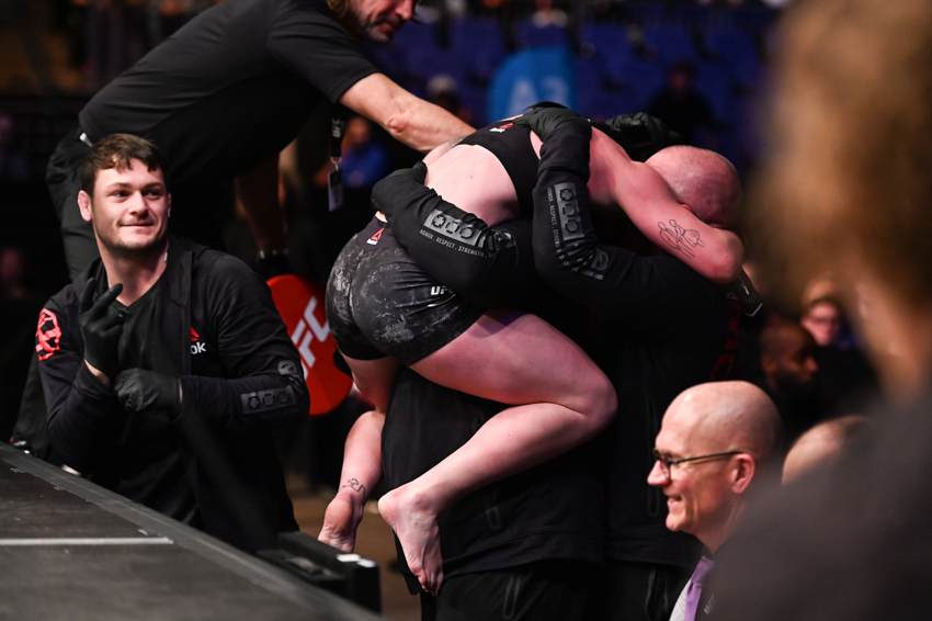  Despite her battered and bloodied eye, Molly McCann dived over the cage to celebrate