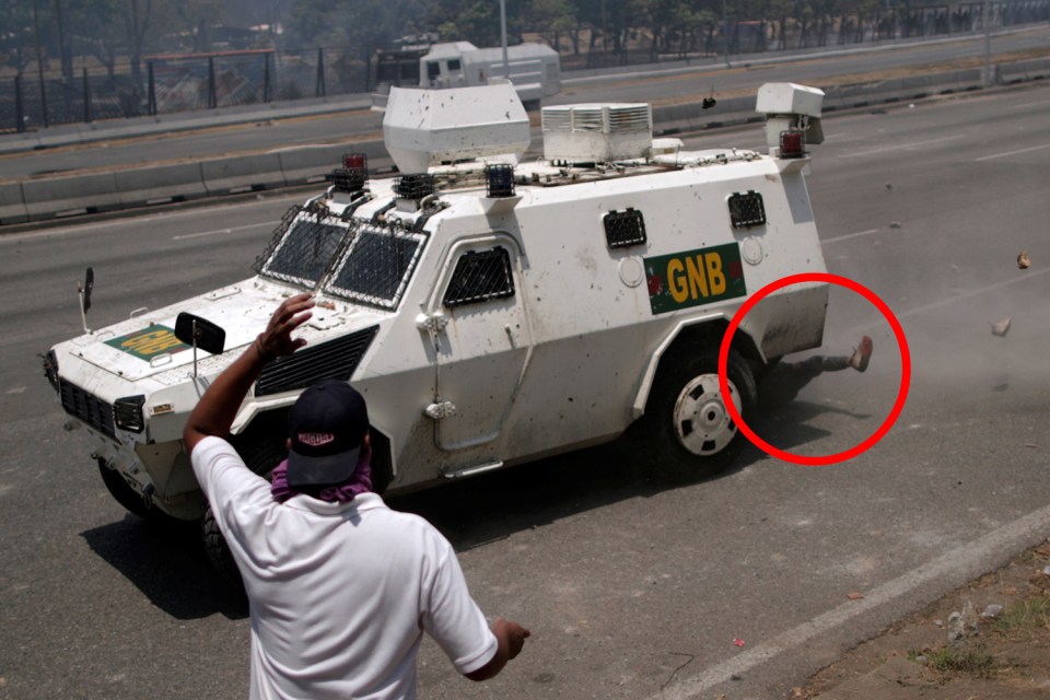 The legs of a demonstrator can be seen after being run overt by a regime personal carrier in 2019