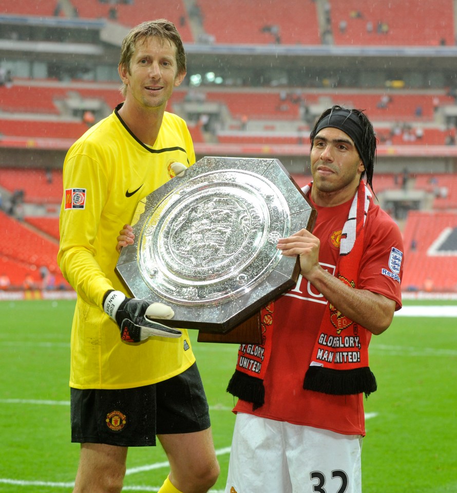  Edwin van der Sar poses with the Charity Shield with Carlos Tevez during his time at Manchester United