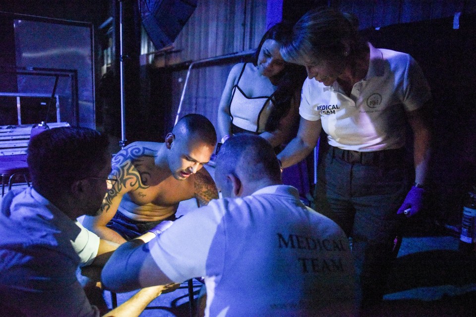  A boxer's partner looks on as he is treated behind the ring following his fight