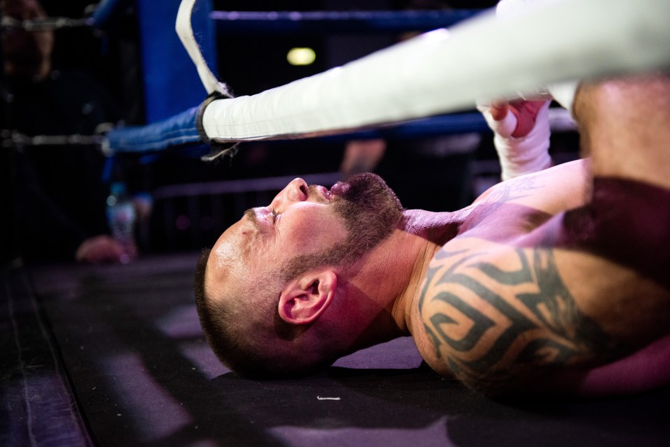  Tattoo-clad boxer grimaces as he's hits the canvas after landing a heavy punch