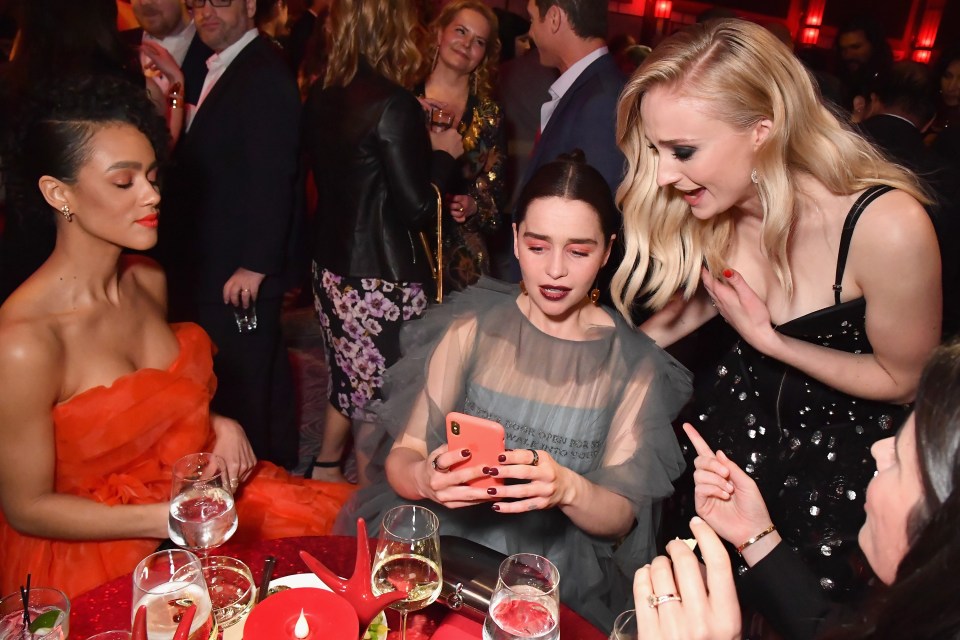  Sophie laughs at something on Emilia's phone