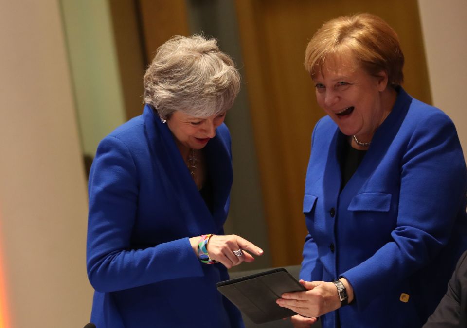  Mrs May and Angela Merkel sharing a joke about wearing a similar jacket