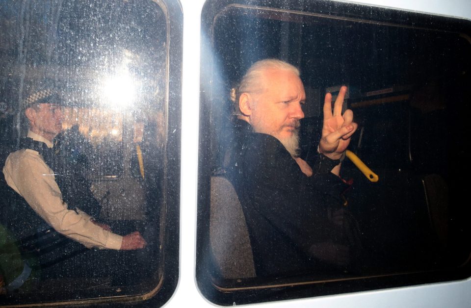  Assange flashed a peace sign in handcuffs