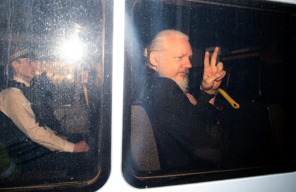  The WikiLeaks founder also gestures a 'peace sign' to the media