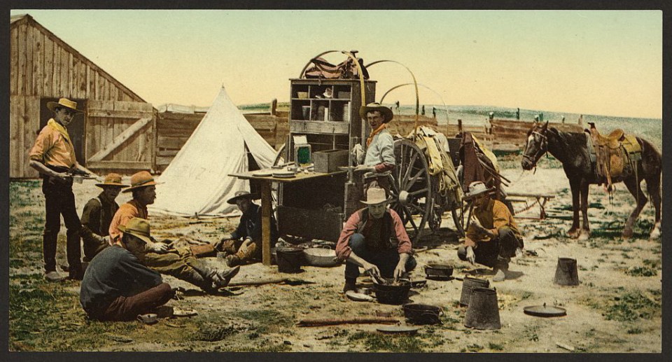 Grub’s up for these Wild West pioneers, eating beside their makeshift canteen