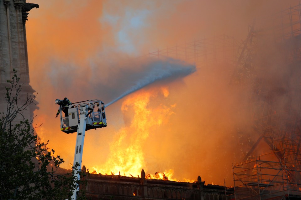  Jets of water are sprayed onto the roof of the medieval landmark