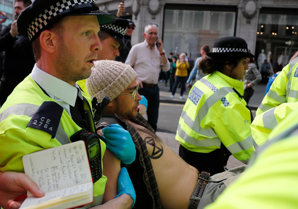  Police carry a protester from Oxford Circus yesterday as arrest numbers climb over 400