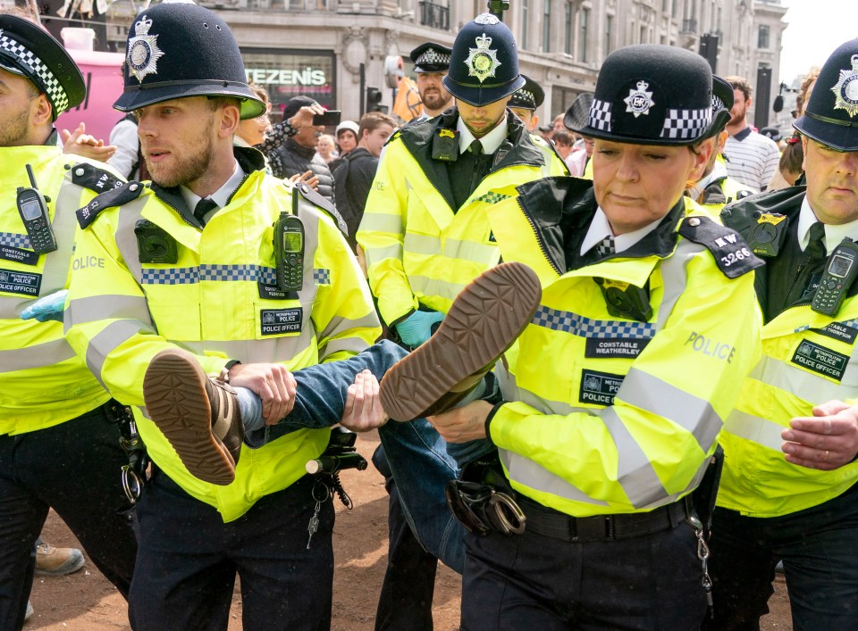  Extinction Rebellion climate change protesters have been asked to swarm Heathrow Airport tomorrow as Easter holidays begin - pictured is a protester being removed from Oxford Circus