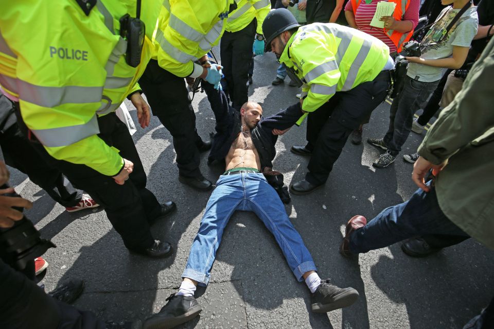  One man lays on the ground to stop police from arresting him