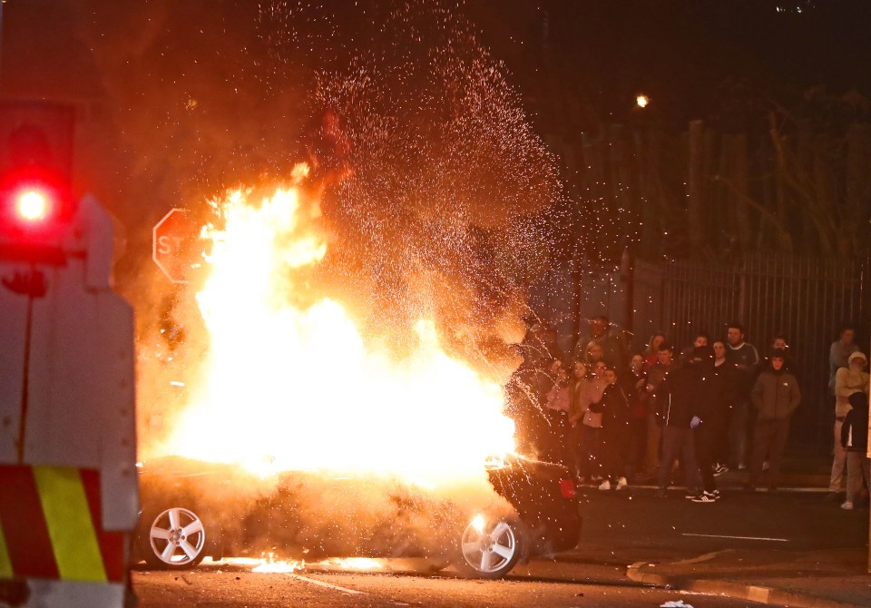 A car goes up in flames tonight as kids watch on