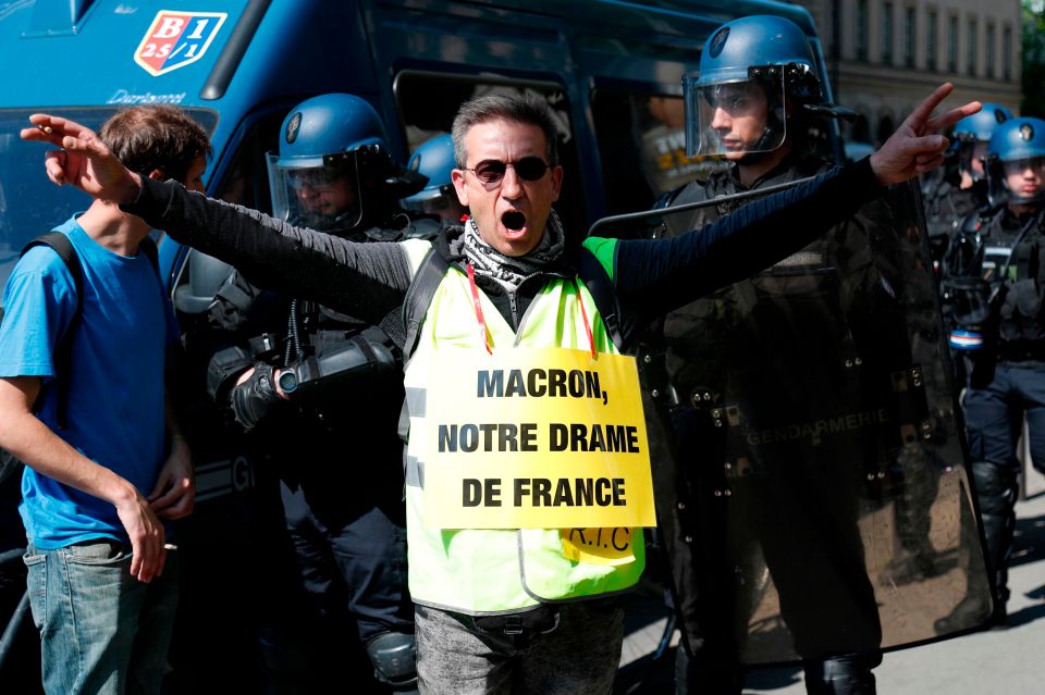  A protester wearing a sign reading 'Macron, our French drama' in reference to the fire that devastated the Notre Dame