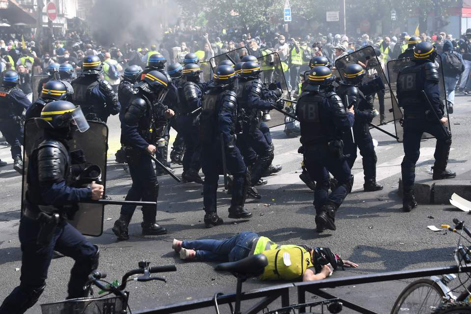  A protester lies on the ground during clashes with police on April 20 in Paris