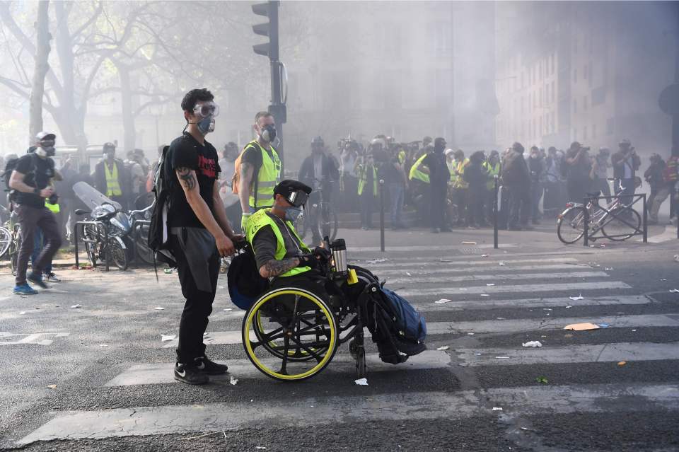  A protester in wheelchair sits amid tear gas during clashes with police