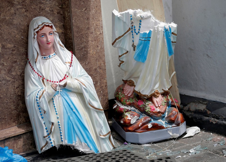  A statue of the Virgin Mary broken in two parts at the front of the bombed St Anthony's Shrine