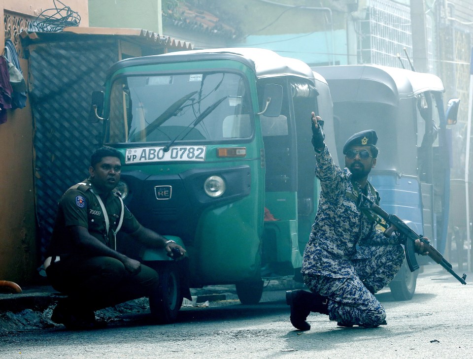  An armed cop gives orders on the street of Colombo in the aftermath of the attacks