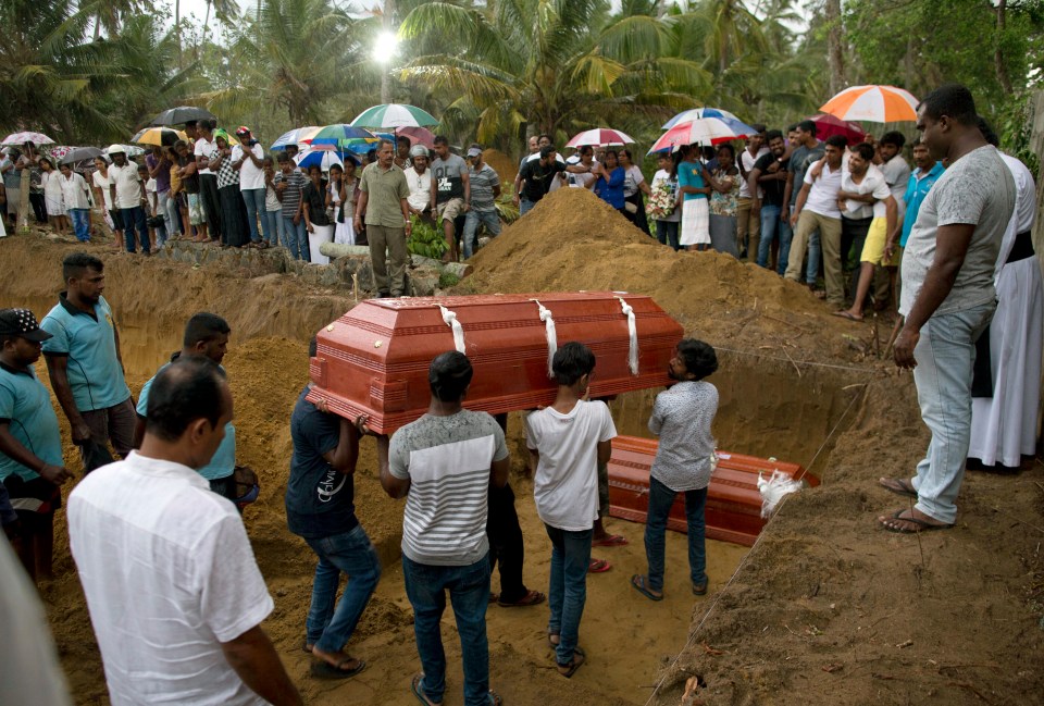  Relatives carry a coffin at the funerals of three members of the same family killed at St Sebastian Church