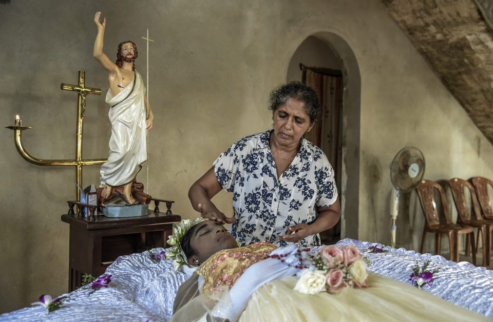  A woman washes the dead body of her granddaughter, 27, in Negambo after she was killed in the horrific bomb attacks