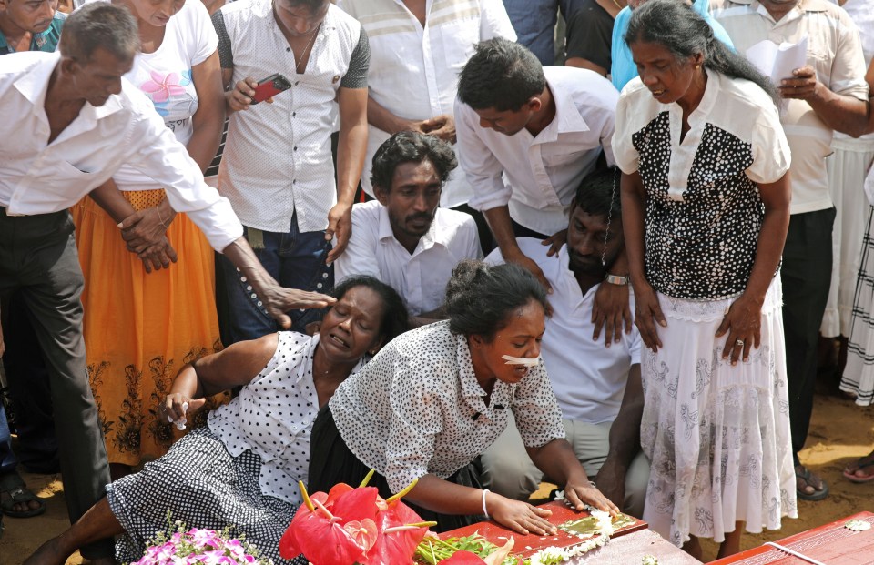  Families grieve for their loved ones during a funeral at a cemetery near St Sebastian Church in Negombo