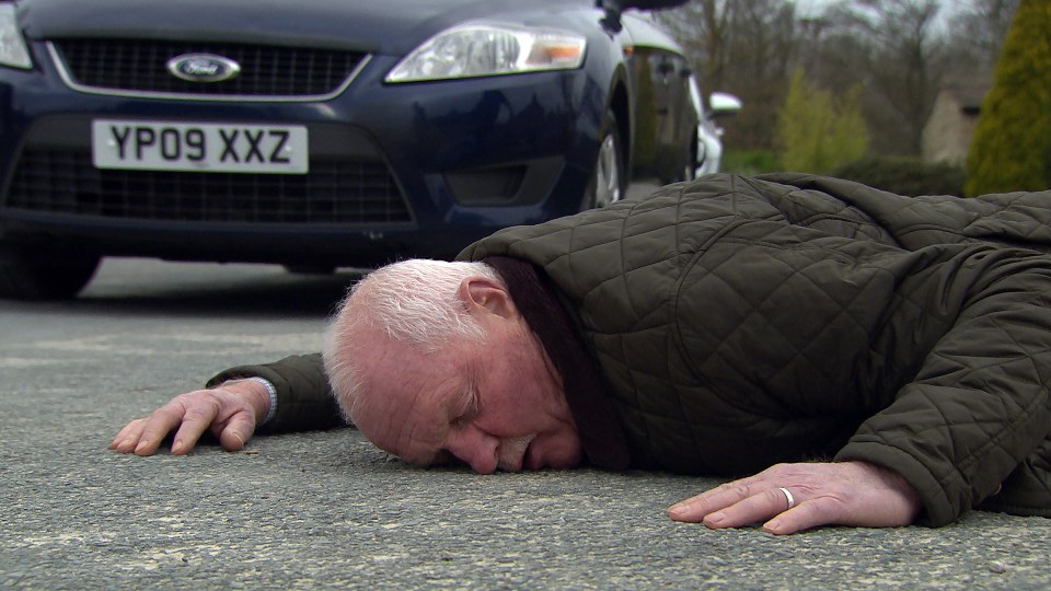  Eric lies unconscious on the road after being knocked down