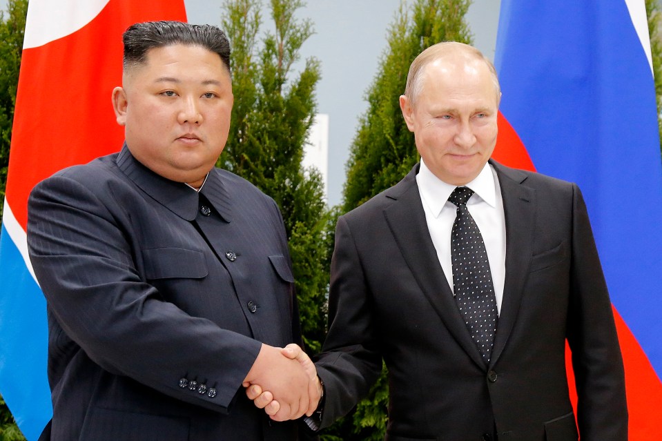  Kim and Putin shaking hands as the North Korean leader arrived in Vladivostok in Russia