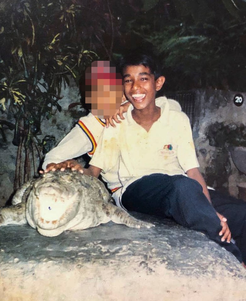  Mohamed smiles with a pal while holding a crocodile