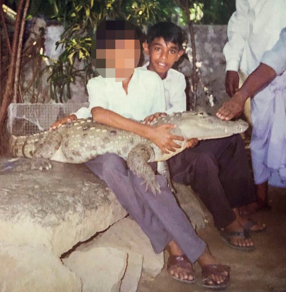  Mohamed smiles with a pal while holding a crocodile