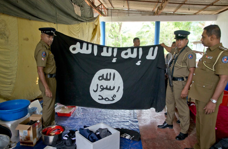  Police in Ampara show explosives, chemicals and the Islamic State flag they recovered during raids