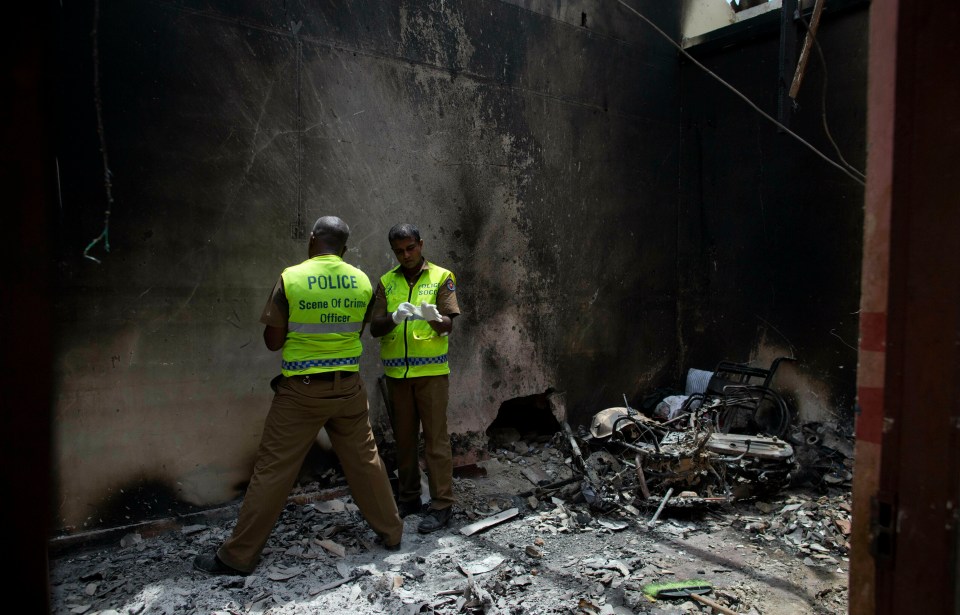  A police officer inspects the site of a gun battle between troops and suspected Islamist militants on the east coast of Sri Lanka