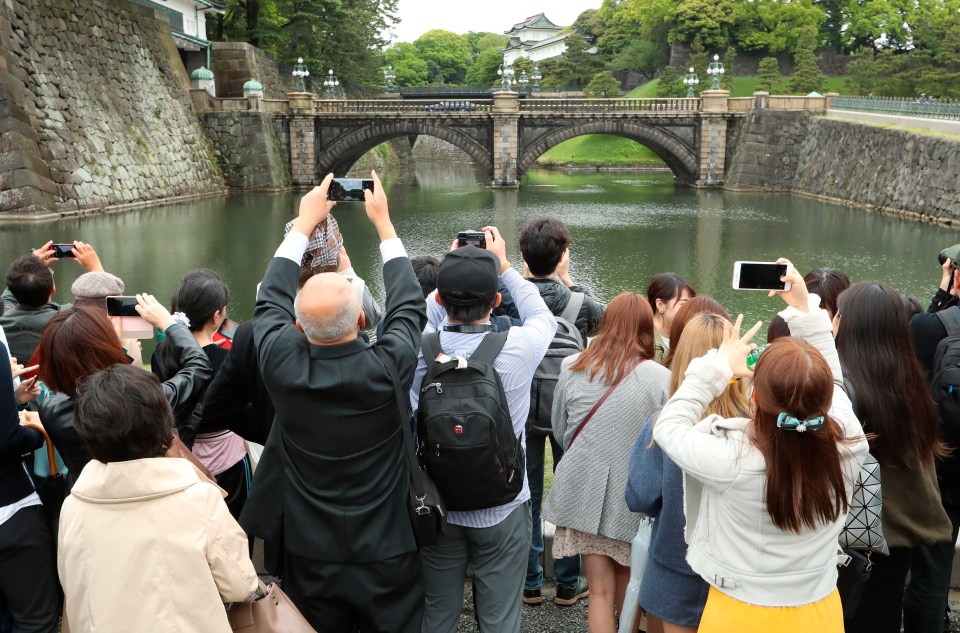 People take photos of the famous double bridge in the compound of Imperial Palace in Tokyo