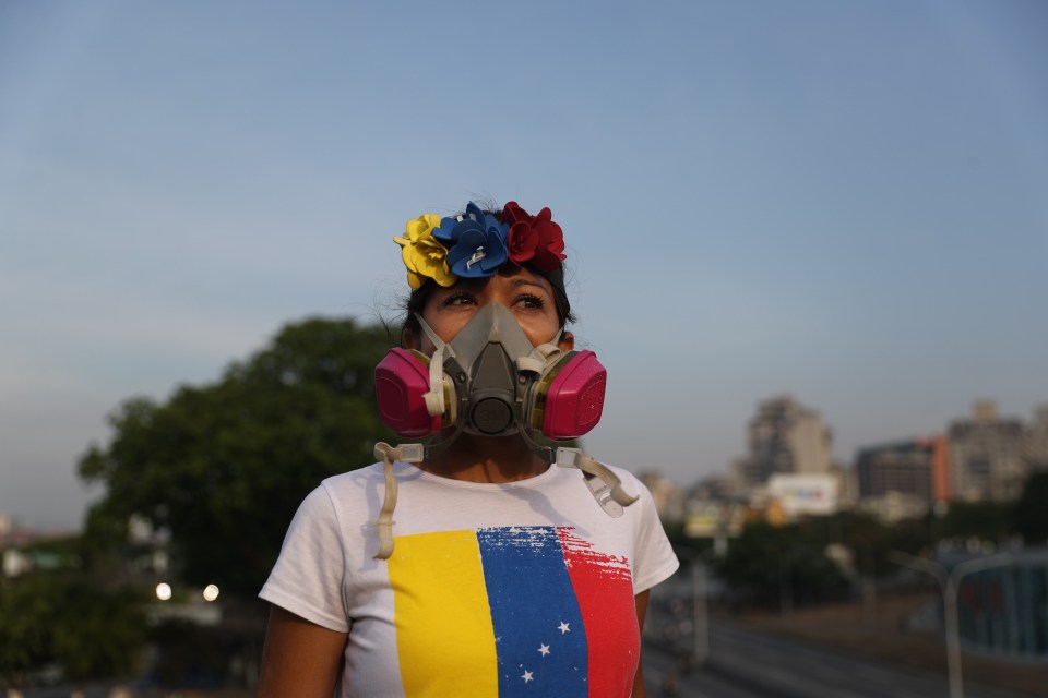  A Guaido supporter uses a gas mask to protect herself from the tear gas launched by the security forces loyal to Nicolas Maduro