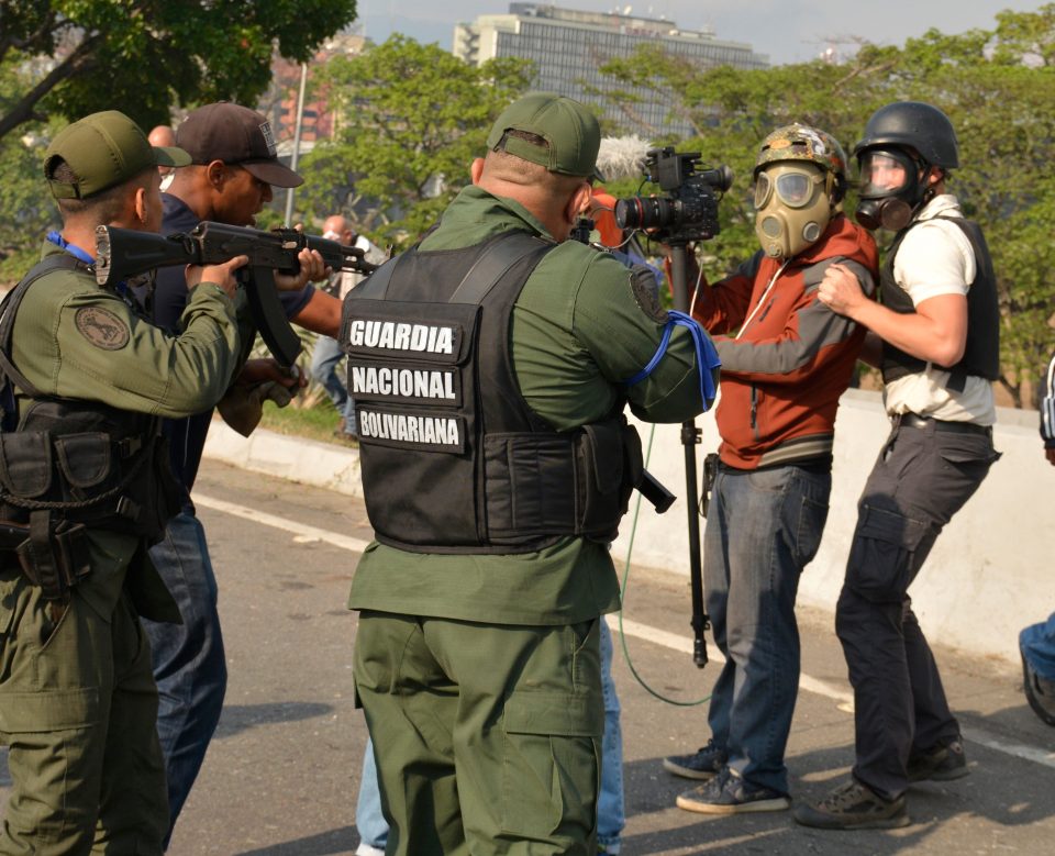  Pro-Guaido soldiers point their weapons towards a cameraman