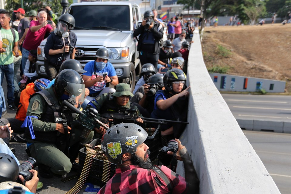  TRoops rebelling against the government of Maduro take cover on an overpass