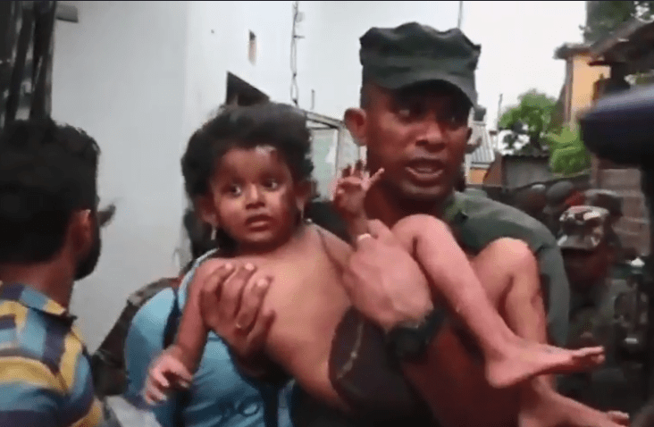  A soldier carries a young girl who was in injured in the crossfire during the raid