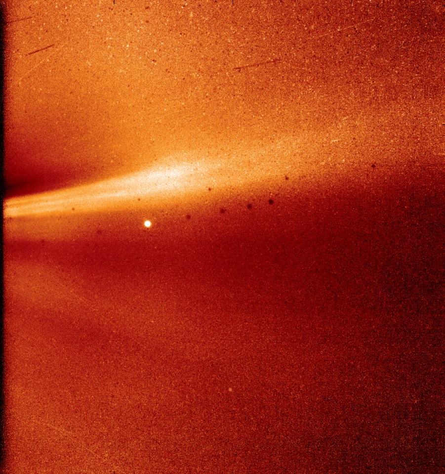 WISPR image of a bright streak across a dark, reddish-brown background.