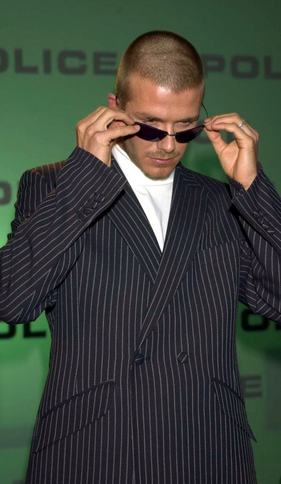 David Beckham posing in a pair of police sunglasses in a striped suit