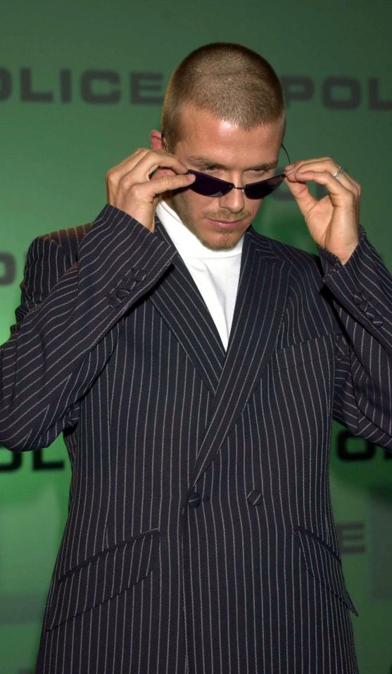  David Beckham posing in a pair of police sunglasses in a striped suit